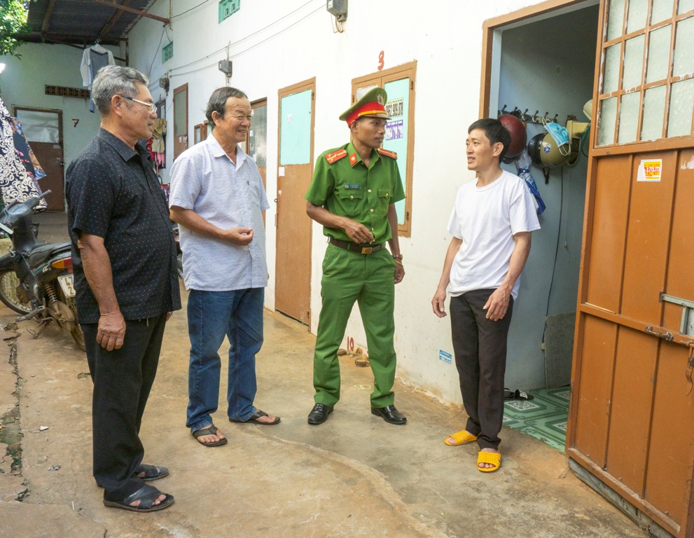 Trưởng buôn Mduk Ama Minh (bìa trái) cùng cán bộ Công an phường Ea Tam nắm  thông tin về tình hình an ninh, trật tự tại buôn.  