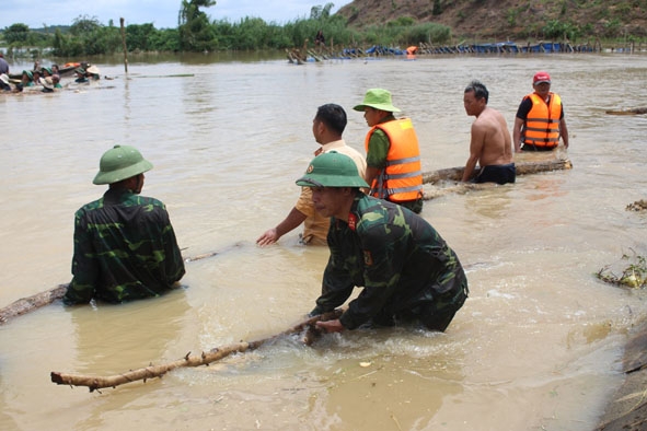 Cán bộ, chiến sĩ Ban CHQS huyện Krông Ana cùng nhân dân khắc phục sự cố vỡ đê bao Quảng Điền.  