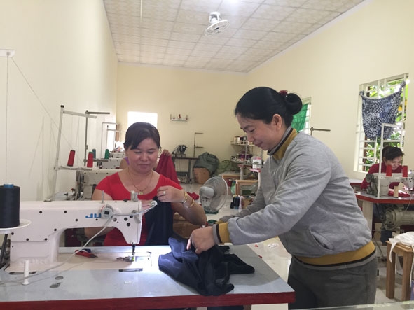 Chị Nguyễn Thị Bích Lan (bên phải) kiểm tra sản phẩm may của công nhân tại cơ sở. 