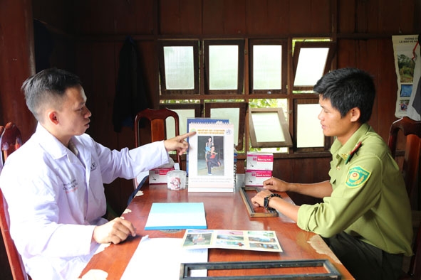 Cán bộ chuyên trách sốt rét Trạm Y tế xã Krông Na  (bên trái) tuyên truyền cho người dân về phòng bệnh sốt rét.