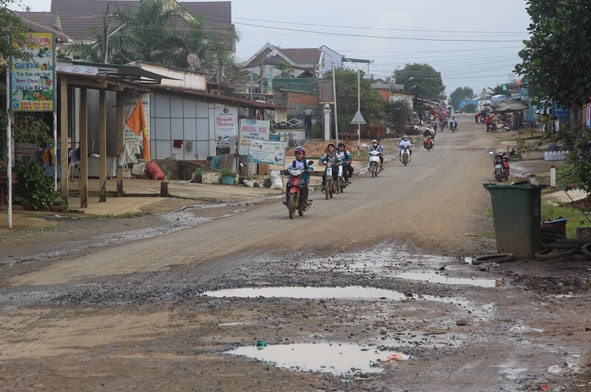 Mặt đường  của Quốc lộ 19C, đoạn qua  huyện M'Đrắk đã bị bong tróc, hư hỏng  gây khó khăn trong việc đi lại của người dân. 
