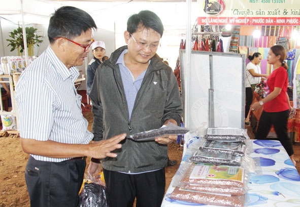 Ông Lã Như Kỹ, Giám đốc HTX Cánh đồng 8-4 (bên trái) giới thiệu sản phẩm gạo đen Phúc Thọ đến người tiêu dùng. 