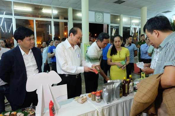 Chủ tịch UBND tỉnh Phạm Ngọc Nghị  (thứ hai từ trái sang) và các đại biểu tìm hiểu các sản phẩm khởi nghiệp.