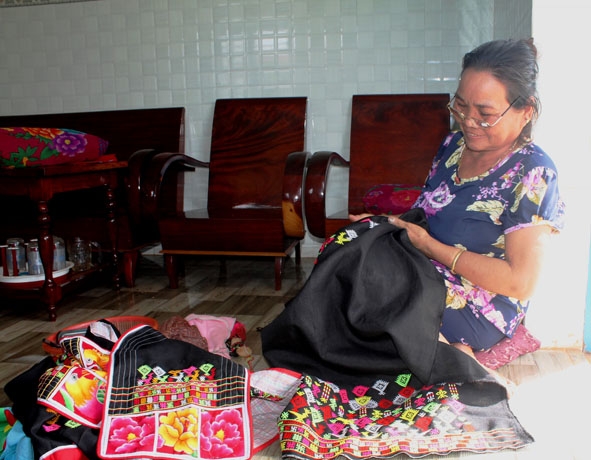 Bà Triệu Thị Minh thêu hoa văn lên trang phục truyền thống.