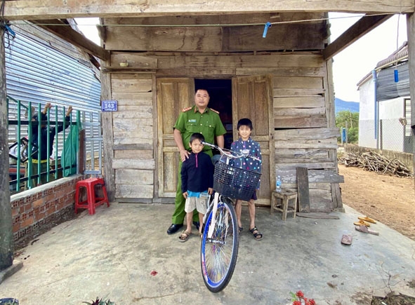 Đại úy Lê Tấn Thành trao tặng xe đạp cho hai người con của chị Nguyễn Thị Loan  (thôn 6, xã Vụ Bổn).