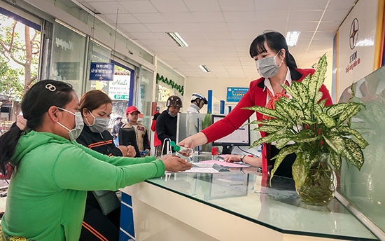 Nhân viên Điện lực Đắk Lắk phát khẩu trang y tế và hướng dẫn khách hàng vệ sinh khử trùng tay