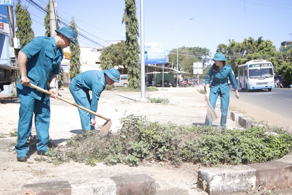 Lực lượng DQTV xã Hòa Hiệp tham gia giúp dân dọn dẹp vệ sinh môi trường. 