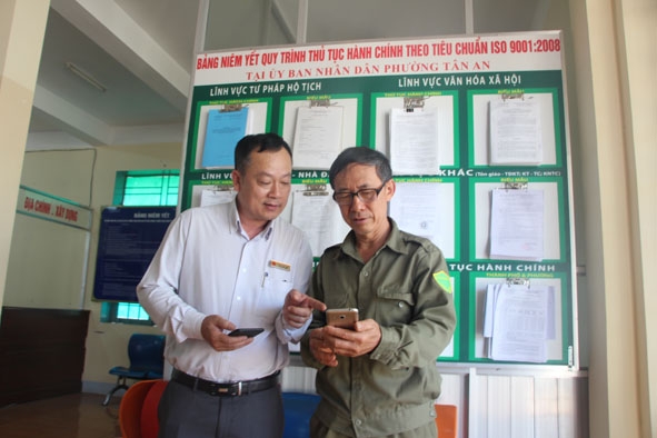 Ông Chu Văn Việt, Chủ tịch UBND phường Tân An (bên trái) hướng dẫn người dân truy cập ứng dụng Zalo  để theo dõi và cung cấp thông tin về an ninh trật tự.  