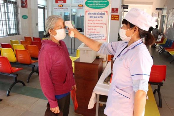 Cán bộ  Bệnh viện  Đa khoa huyện Krông Pắc  đo thân nhiệt  cho người dân  đến khám bệnh. 