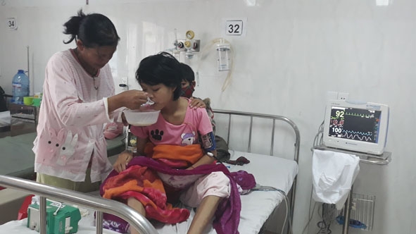 Bà Đinh Thị Nga Tuyết chăm sóc con ở bệnh viện. 