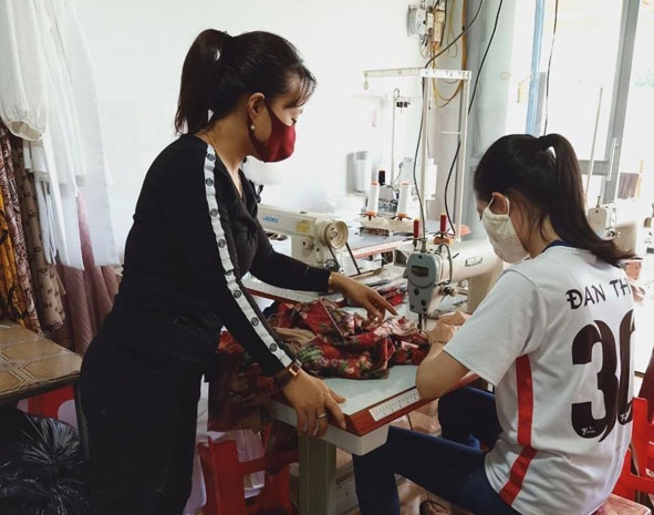 Thành viên  Tổ may  gia công  của Chi hội phụ nữ  tổ dân phố 1 (phường  Bình Tân)  lắp ráp hàng may mặc. 