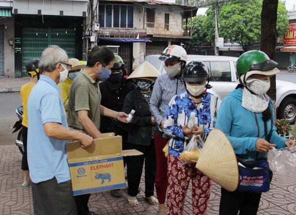 Người lao động tự do nhận nước rửa tay phòng dịch Covid-19 tại phường Thống Nhất (TP. Buôn Ma Thuột).