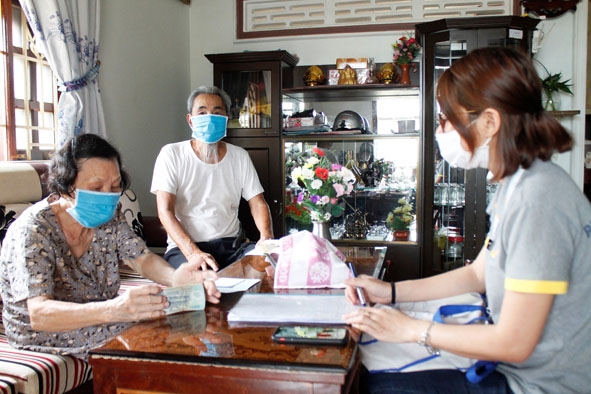 Nhân viên Bưu điện TP. Buôn Ma Thuột chi trả lương hưu tại nhà cho người dân ở phường Tân Thành. 