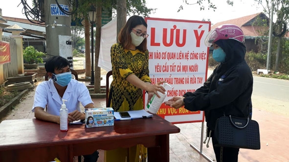 Người dân được khuyến cáo đeo khẩu trang và rửa tay sát khuẩn khi đến trụ sở UBND xã Cư Yang (huyện Ea Kar) liên hệ giải quyết công việc. 