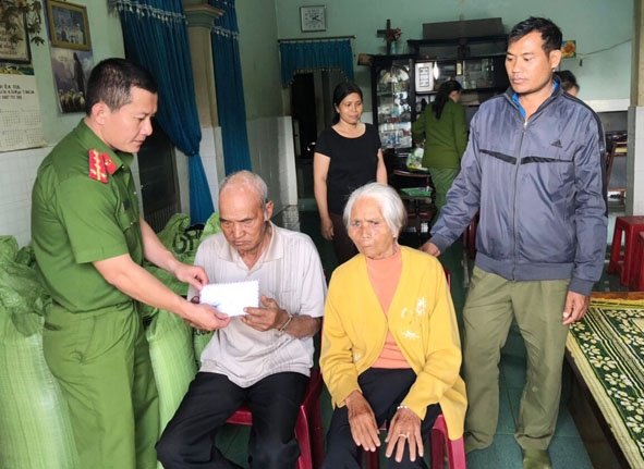 Đại diện Đoàn cơ sở Công an huyện Cư M'gar tặng quà cho gia đình chính sách trên địa bàn  thị trấn Quảng Phú. 