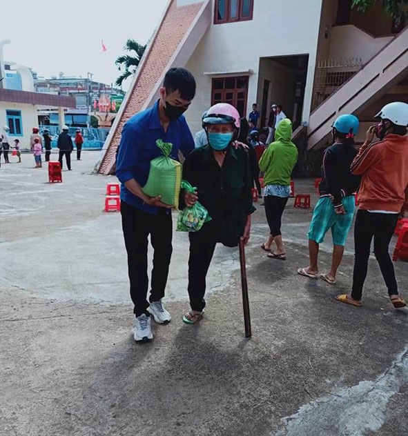 Đoàn viên  thanh niên  huyện Krông Ana hỗ trợ người dân  đến nhận gạo. 