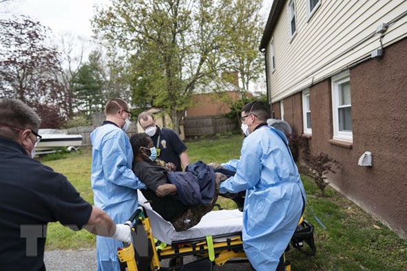 Nhân viên y tế hỗ trợ chuyển bệnh nhân Covid-19 tại Glen Burnie, Maryland (Mỹ) ngày 25-4. (Ảnh: AFP/TTXVN)