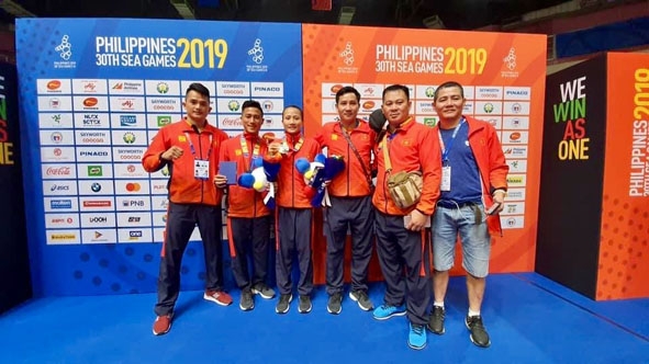 Võ sĩ Phạm Bá Hợi (thứ 2 từ trái sang) cùng đồng đội, Ban huấn luyện đội tuyển kick boxing tại SEA Games 30. ( Ảnh nhân vật cung cấp)