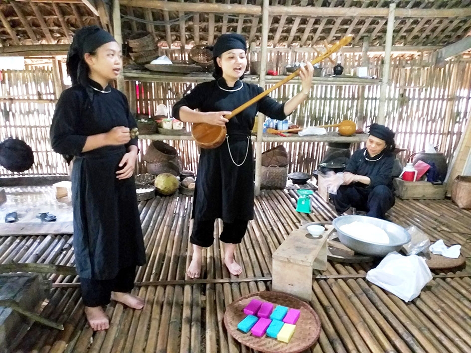 Đồng bào Tày Lâm Bình biểu diễn hát then trên không gian nhà sàn. 