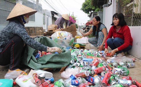 Các thành viên mô hình “Thu gom rác thải gây quỹ từ thiện” của phụ nữ tổ dân phố 4 (phường Tân Tiến) đang phân loại phế liệu. 