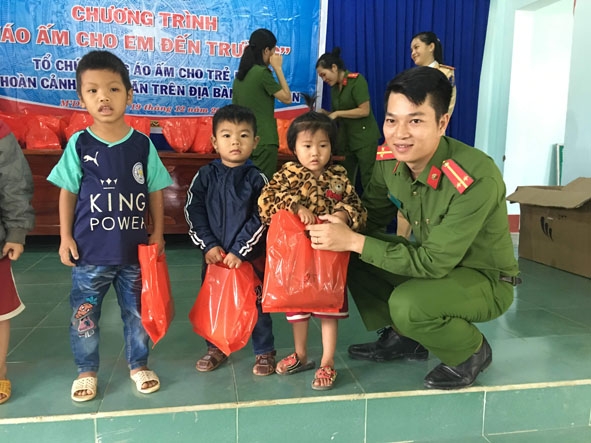 Trung úy Nguyễn Hồng Hoài Thương tặng quà thiếu nhi tại xã Cư San.