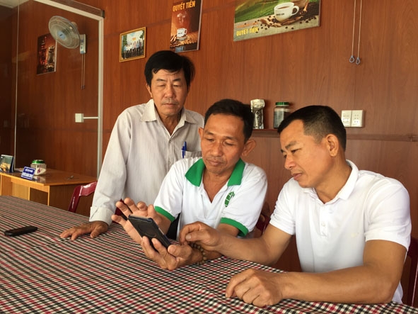 Nông dân xã Quảng Hiệp sử dụng điện thoại để điều khiển việc tưới nước cho vườn cây.