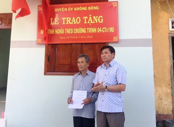 Bí thư Huyện ủy  Krông Bông  Đỗ Quốc Hương (bên phải)  trao quyết định tặng nhà  Tình nghĩa  cho gia đình ông Mai Văn Trung  ở tổ dân phố 2, thị trấn Krông Kmar. 