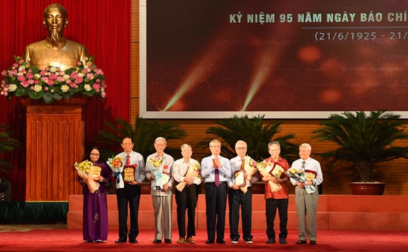Ủy viên Bộ Chính trị, Thường trực Ban Bí thư Trung ương Đảng Trần Quốc Vượng tặng hoa và biểu trưng vinh danh cho các nhà báo lão thành tại Hội nghị 