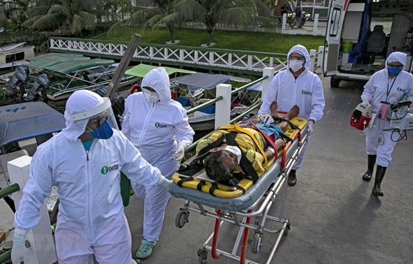 Nhân viên y tế chuyển bệnh nhân mắc Covid-19 tới một bệnh viện ở bang Para, Brazil. (Ảnh: AFP/TTXVN)
