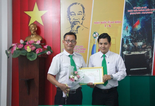Đại diện lãnh đạo Chi nhánh Công ty Cổ phần Tập đoàn Mai Linh tại Đắk Lắk tặng hoa và Giấy khen cho tài xế Phạm Văn Sỹ (bên trái).
