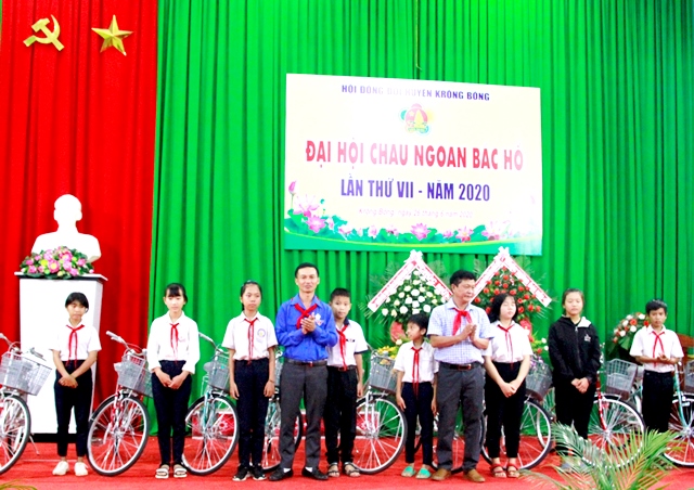Đại diện Hội đồng Đội huyện Krông Bông tặng xe đạp cho các em học sinh nghèo vượt khó.