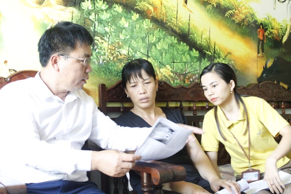 Cán bộ BHXH TP. Buôn Ma Thuột và nhân viên bưu điện xã Hòa Khánh tuyên truyền các chính sách bảo hiểm đến người dân.  