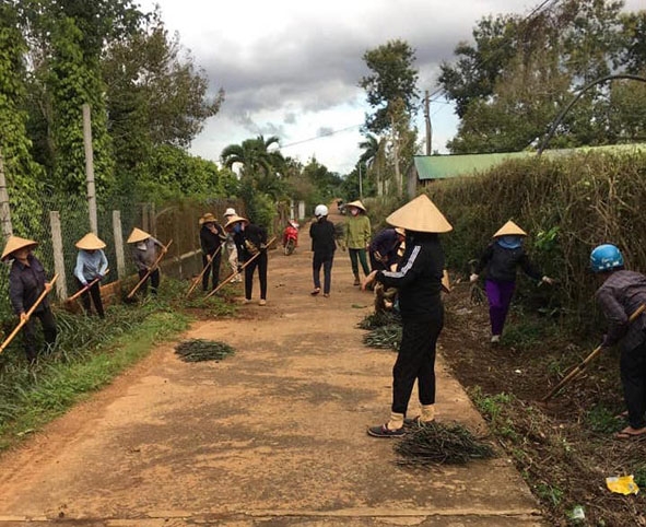 Phụ nữ xã  Cư Dliê M’nông tham gia dọn dẹp vệ sinh môi trường.