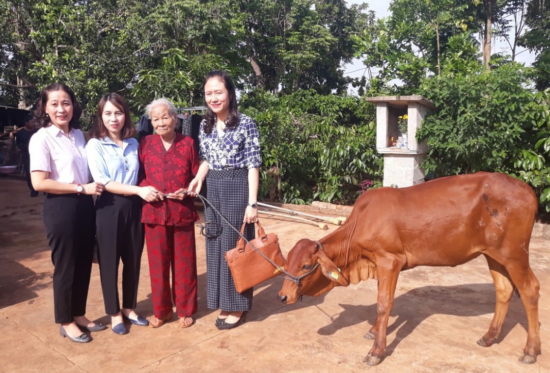 Bà Hoàng Thị Niềm (thứ hai từ phải sang) nhận mô hình hỗ trợ bò sinh sản.