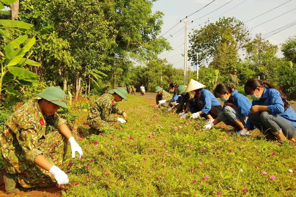 Các chiến sĩ Trung đoàn 584 tham gia làm trồng hoa trên các trục đường thuộc xã 