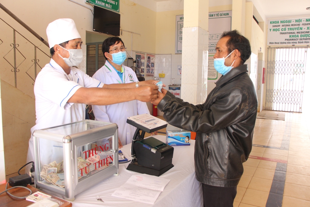 Cán bộ Trung tâm Y tế huyện Cư Kuin phát khẩu trang miễn phí và hướng dẫn người dân cách sử dụng.