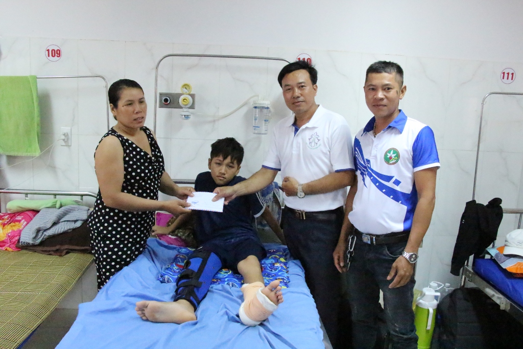 Đại diện Hội Bảo tồn lan rừng Việt Nam trao tiền hỗ trợ em Trần Nhật Tân.    