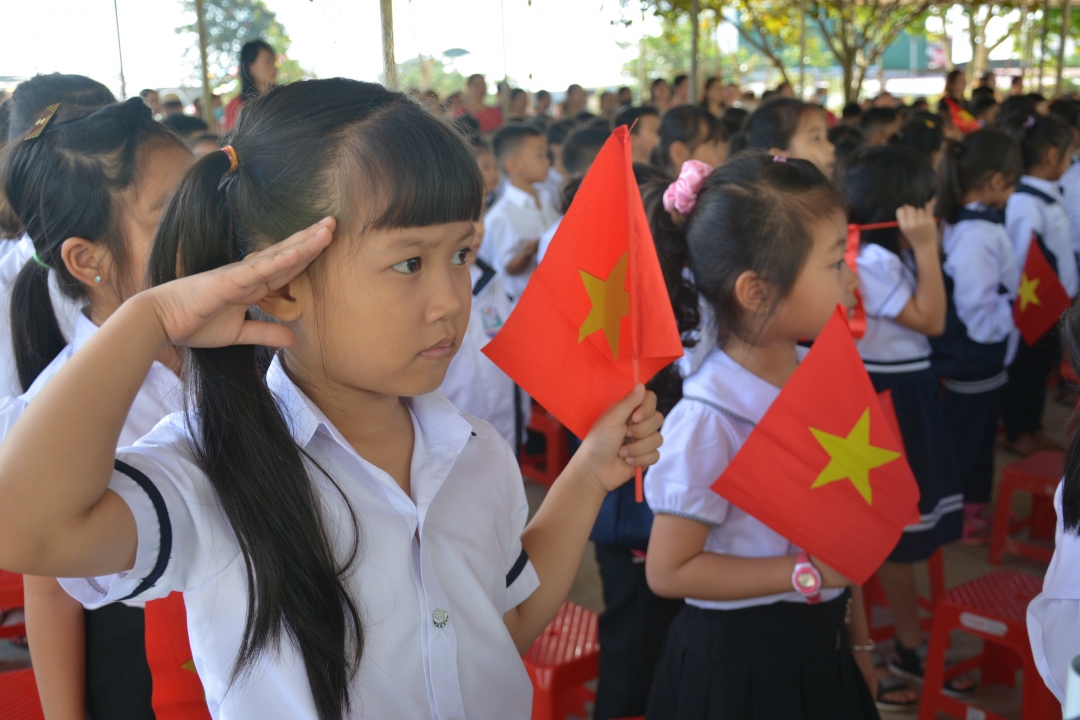 Em Nguyễn Kim Diệp, học sinh lớp 1B, nghiêm trang chào cờ tại Lễ khai giảng.