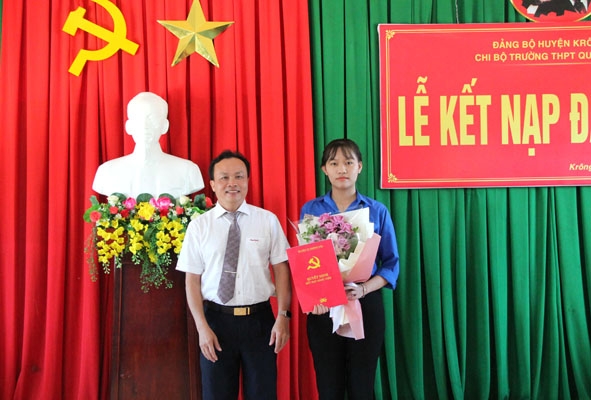 Phó Bí thư Thường trực Huyện ủy Krông Pắc Trần Quốc Vĩnh trao Quyết định kết nạp đảng viên cho đảng viên mới Lê Hoàng Bảo Nhi (lớp 12A1, Trường THPT Quang Trung).