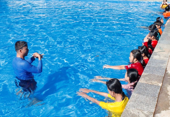 Thầy Lê Hải Châu (giáo viên Trường THCS Hùng Vương, xã Bình Thuận, thị xã Buôn Hồ) hướng dẫn các em học sinh kỹ thuật bơi. 