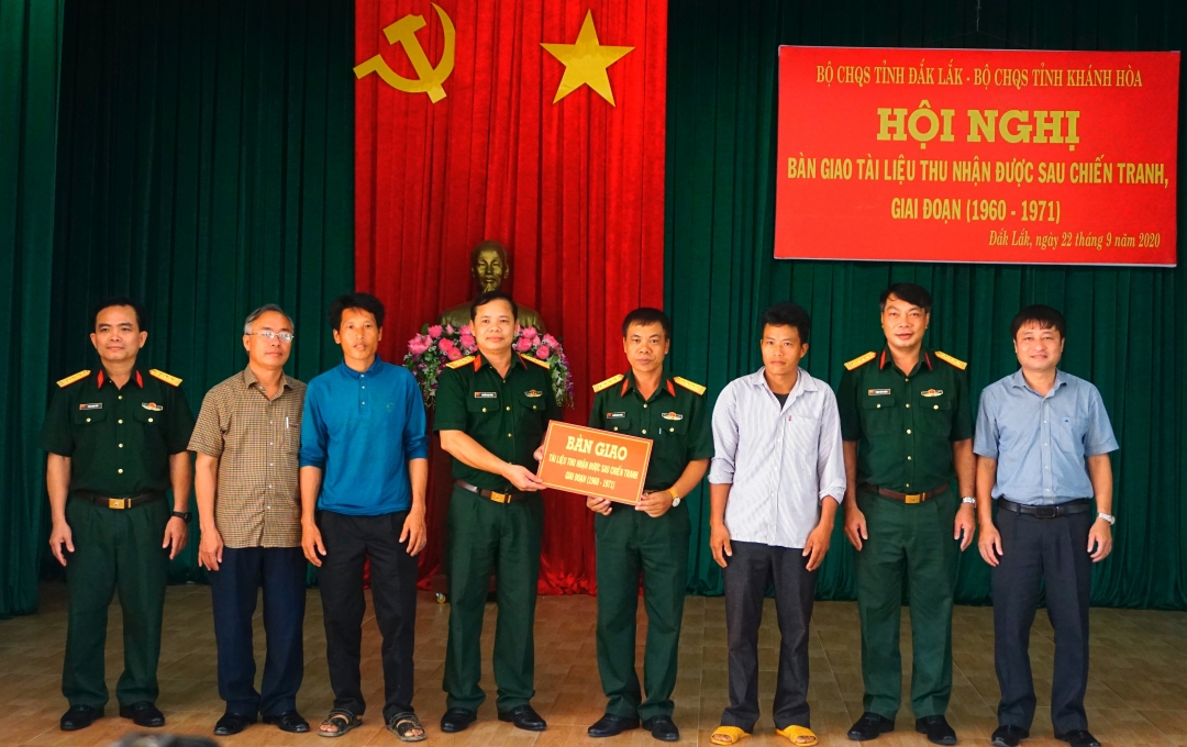 Đại diện Bộ CHQS tỉnh và lãnh đạo huyện MDrắk trao biểu trưng tài liệu cho Bộ CHQS tỉnh Khánh Hòa.