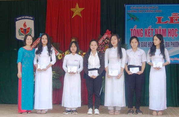 Cô Sương (bìa trái) trao học bổng cho học sinh nhà trường.