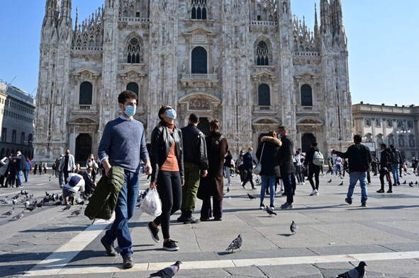 Người dân đeo khẩu trang phòng dịch Covid-19 tại Quảng trường del Duomo ở Milan, Italy. Ảnh: AFP/TTXVN