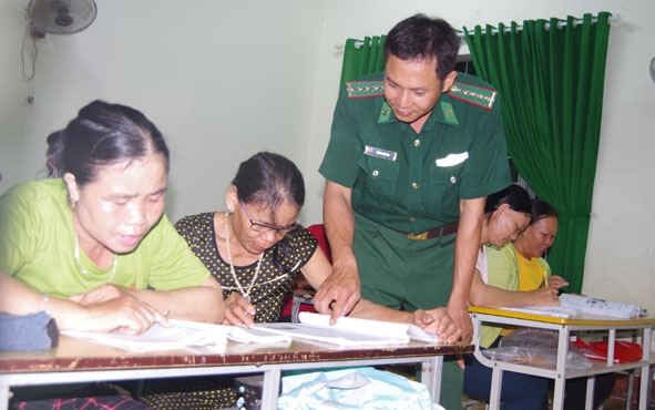 Bà Lữ Thị Sáng (giữa) được thầy giáo tận tình hướng dẫn cách ghép vần.  