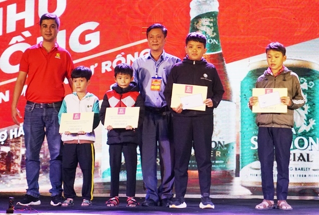 Đại diện Công ty Cổ phần thương mại Bia Sài Gòn Tây Nguyên trao học bổng cho các em học sinh.