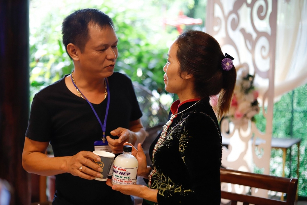 Chị Lù Thị Hạnh giới thiệu các sản phẩm rượu nếp Thái cho khách hàng.  (Ảnh nhân vật cung cấp)