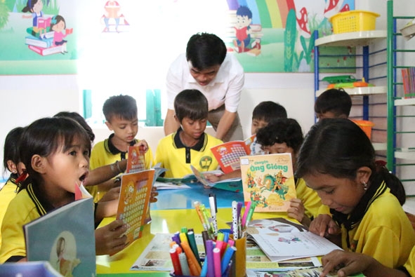 Các em học sinh Trường Tiểu học Đinh Núp đọc sách trong thư viện. 