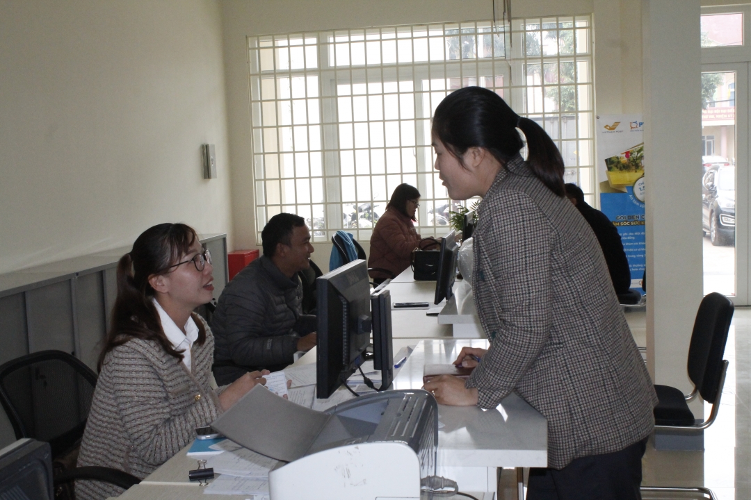 Nhân viên Bưu điện huyện Ea Kar giải đáp các chính sách về BHYT cho người dân. 