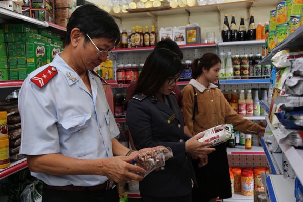 Lực lượng chức năng kiểm tra việc bày bán thực phẩm tại một cửa hàng ở TP. Buôn Ma Thuột.   