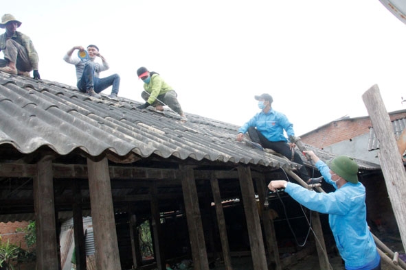 Đoàn viên thanh niên huyện M'Drắk hỗ trợ tháo dỡ mái tôn cho người dân tại thôn 9 (xã Cư San). 